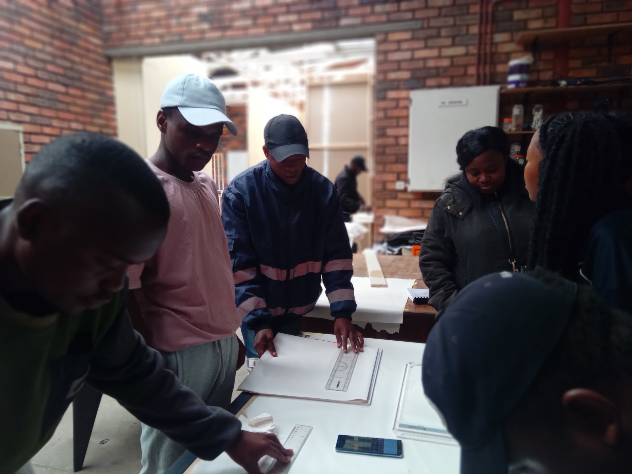AIET students during an engineering drawing and drafting practical session around large drawing tables