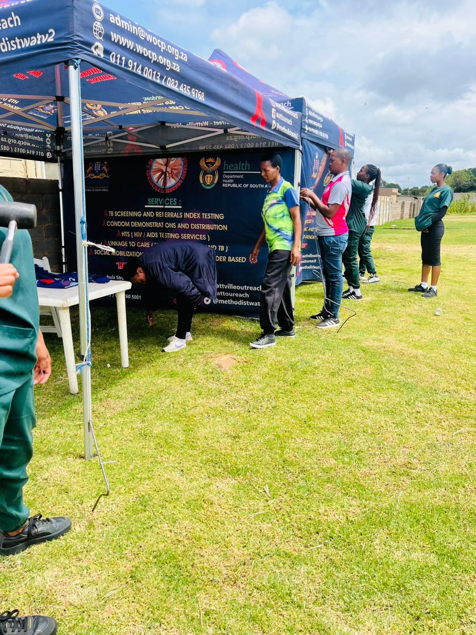 AIET Health Promotion Officer students supporting a community outreach activation under a branded health services tent